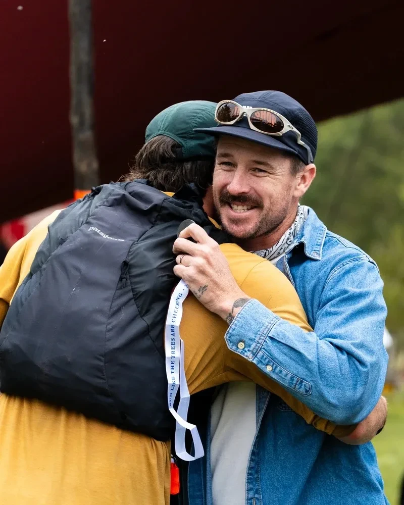 Two people hugging at the finish